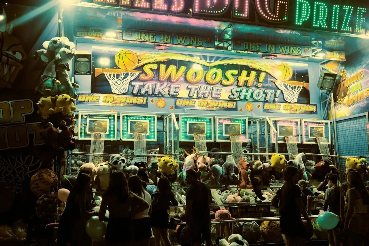 A lively carnival booth at night in Arlington Heights with people enjoying games.