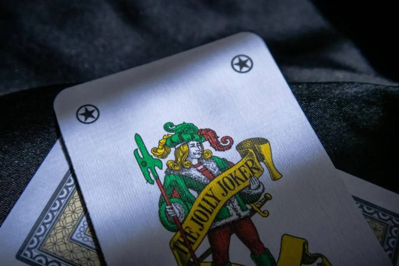 Detailed shot of a Jolly Joker playing card with intricate design in a low light setting.