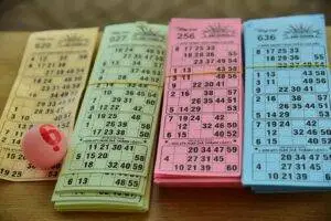 A set of colorful bingo cards and a numbered ball on a table, ready for a game night.
