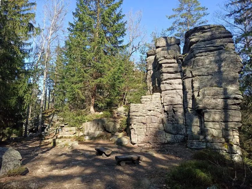 Explore towering rock formations and lush forests in Karkonosze, Poland.